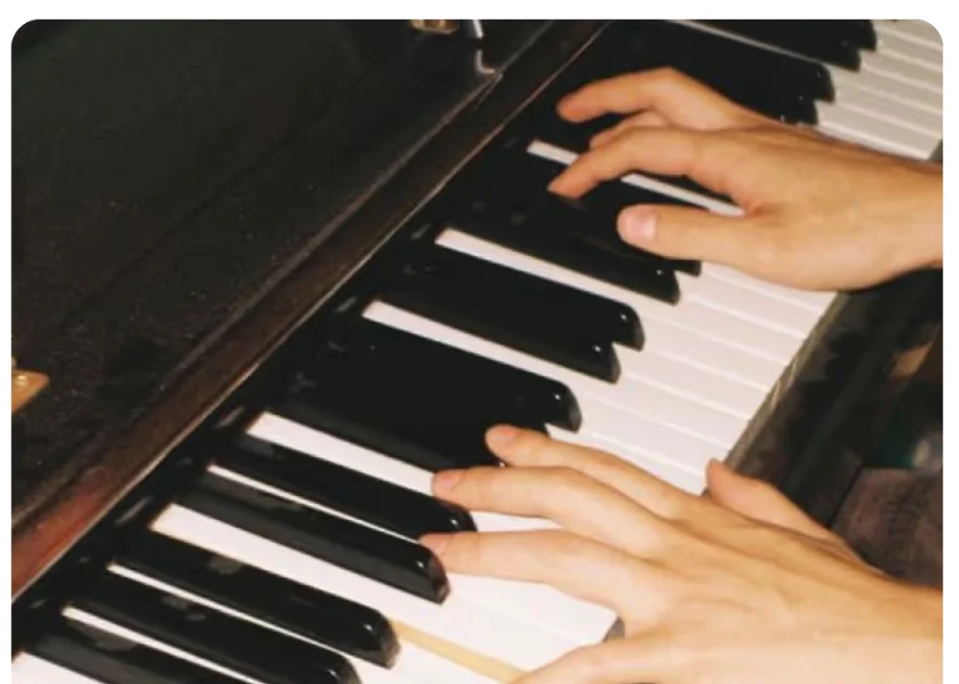 Hands playing piano keys