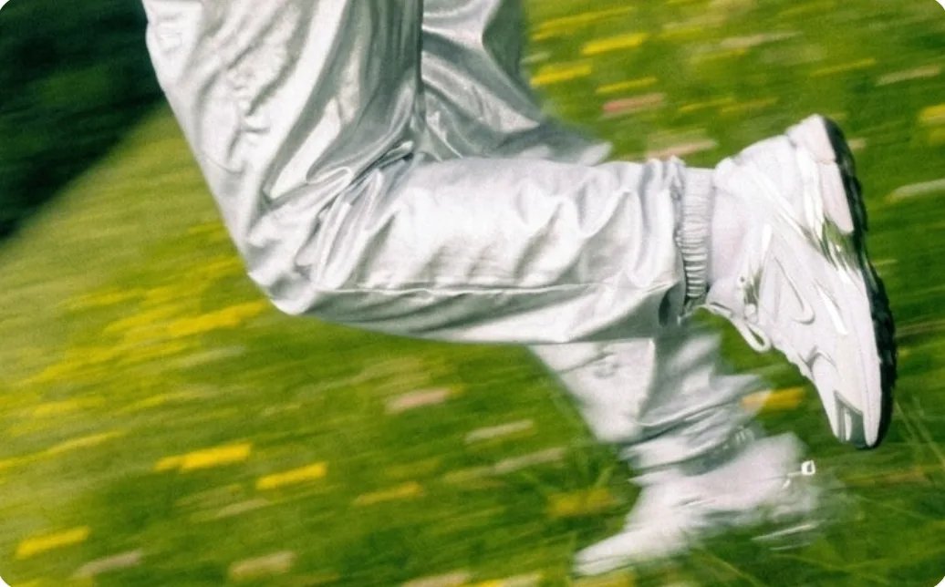 Silver trousers mid-stride on grass